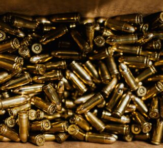 A close-up view of a collection of brass bullets inside a box, highlighting their shiny metallic texture.